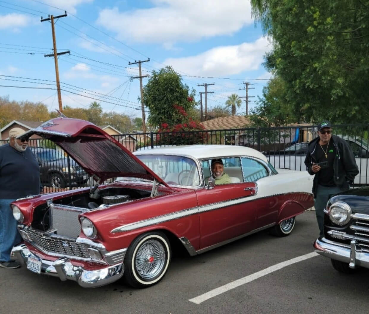 Classic red car with open hood displayed.