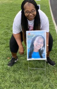 Person crouching next to framed outdoor photo.