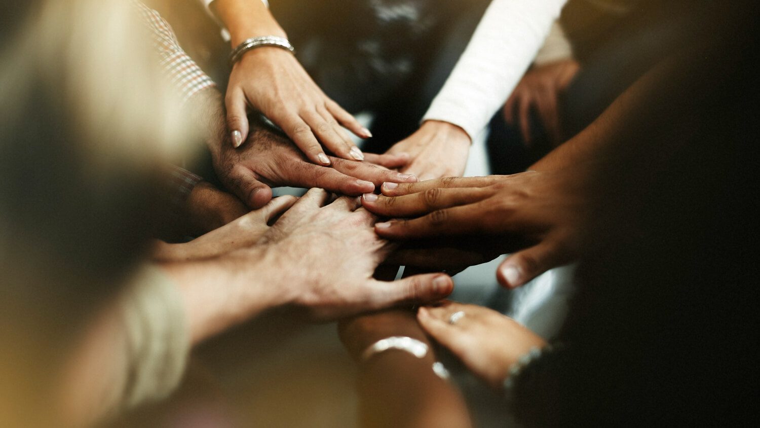 Hands together in a circle, symbolizing unity.
